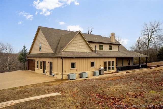 16511 S 4230th Rd, Claremore, OK 74017 - back of property featuring a shingled roof, a chimney, board and batten siding, and concrete driveway