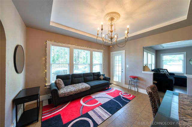 919 S 2nd St, Mcalester, OK 74501 - tiled living room with a chandelier, plenty of natural light, and a raised ceiling