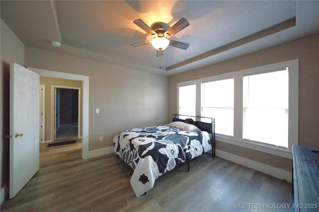 919 S 2nd St, Mcalester, OK 74501 - bedroom featuring a tray ceiling, wood finished floors, and a ceiling fan