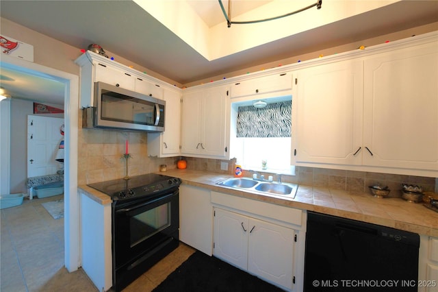 919 S 2nd St, Mcalester, OK 74501 - kitchen featuring black appliances, decorative backsplash, and white cabinetry