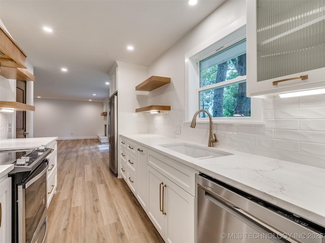 11702 S 75th E Ave, Bixby, OK 74008 - kitchen with open shelves, appliances with stainless steel finishes, light wood finished floors, white cabinetry, and decorative backsplash