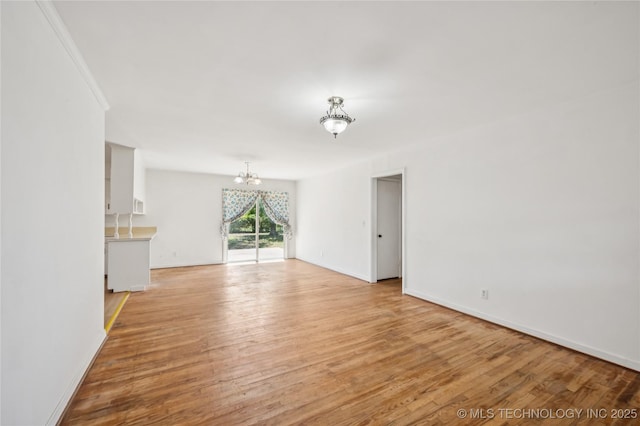 503 N Prairie Ave, Okmulgee, OK 74447 - unfurnished living room with a chandelier and light wood-type flooring