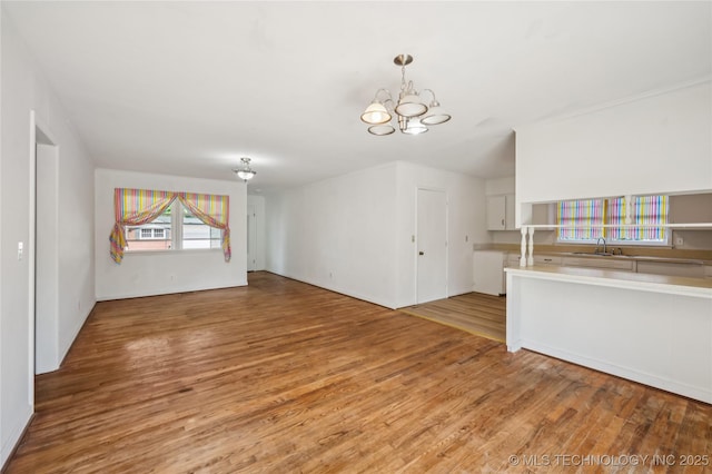 503 N Prairie Ave, Okmulgee, OK 74447 - unfurnished living room with a chandelier and light wood-style flooring