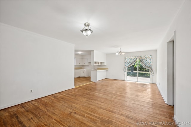 503 N Prairie Ave, Okmulgee, OK 74447 - unfurnished living room with a chandelier and light wood finished floors