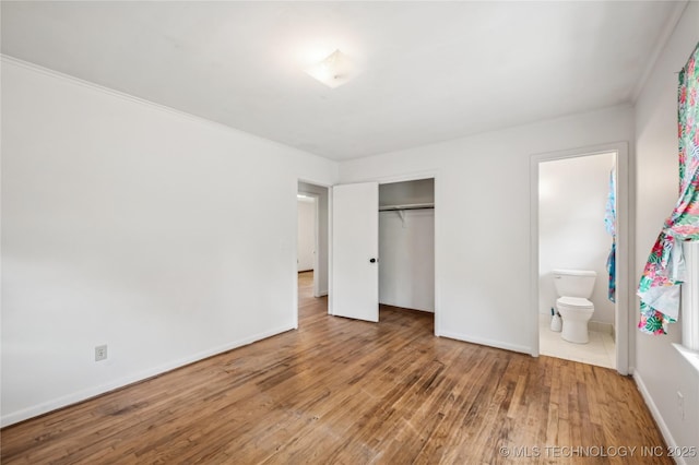 503 N Prairie Ave, Okmulgee, OK 74447 - unfurnished bedroom featuring wood finished floors, a closet, connected bathroom, and ornamental molding