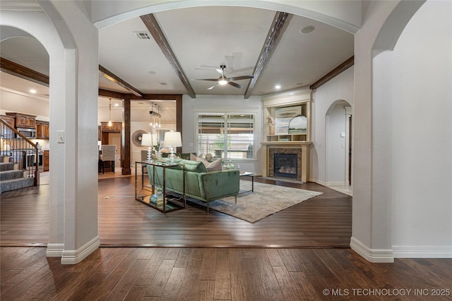 7180 E 179th St S, Bixby, OK 74008 - living area featuring a ceiling fan, stairway, a fireplace with flush hearth, wood-type flooring, and beam ceiling