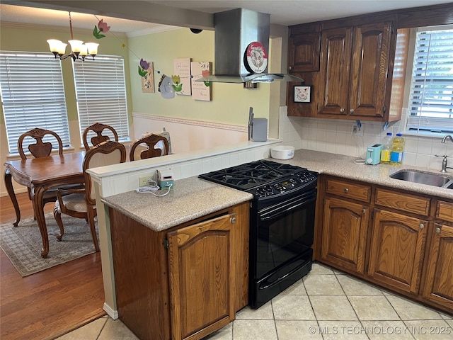 465385 E 981st Rd, Sallisaw, OK 74955 - kitchen with black range with gas stovetop, island exhaust hood, a peninsula, a chandelier, and crown molding