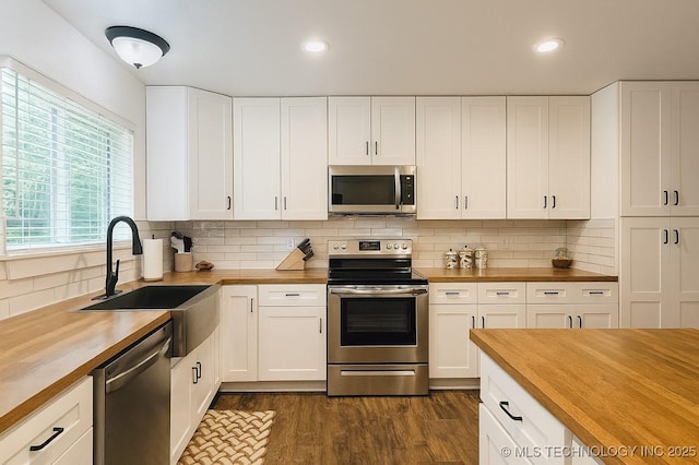 416602 E 1065, Checotah, OK 74426 - kitchen with butcher block countertops, stainless steel appliances, dark wood-type flooring, tasteful backsplash, and recessed lighting