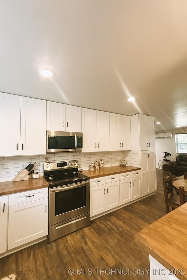 416602 E 1065, Checotah, OK 74426 - kitchen with appliances with stainless steel finishes, wooden counters, a wall mounted AC, tasteful backsplash, and dark wood-type flooring