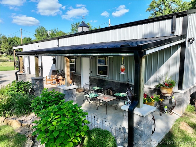 416602 E 1065, Checotah, OK 74426 - back of property featuring a patio area, board and batten siding, a metal roof, and a standing seam roof