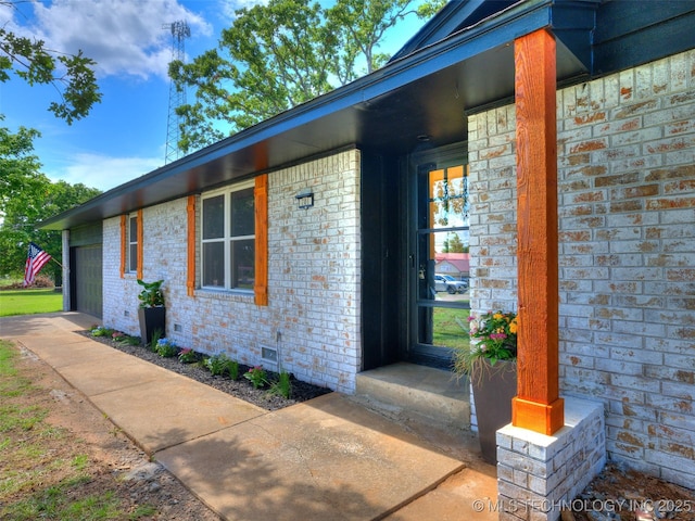 701 W 41st St, Sand Springs, OK 74063 - property entrance with brick siding, a garage, and crawl space
