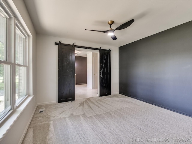 701 W 41st St, Sand Springs, OK 74063 - bedroom with a barn door, light colored carpet, and a ceiling fan