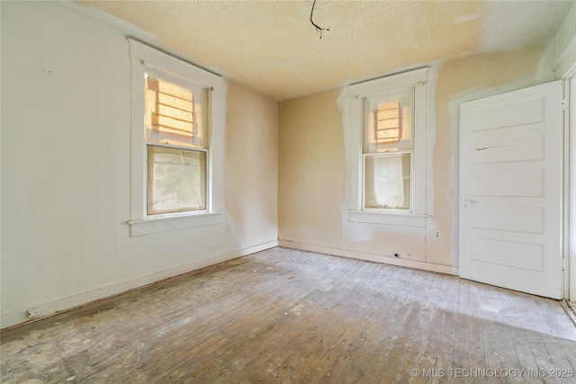 1225 N C St, Muskogee, OK 74403 - spare room featuring hardwood / wood-style floors and a textured ceiling