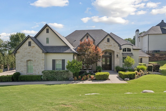 6140 E 140th St S, Bixby, OK 74008 - french country inspired facade with stone siding, french doors, and a front lawn