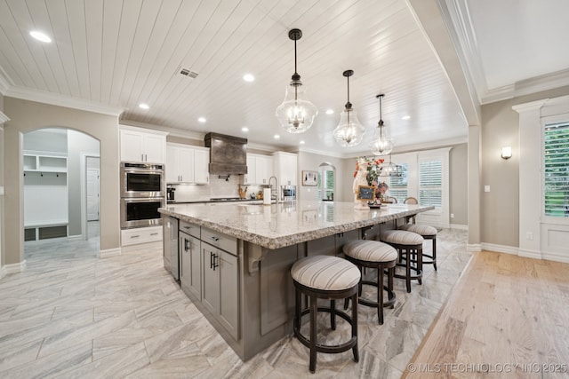 6140 E 140th St S, Bixby, OK 74008 - kitchen with stainless steel double oven, premium range hood, arched walkways, recessed lighting, and ornamental molding