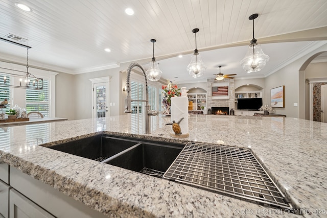 6140 E 140th St S, Bixby, OK 74008 - kitchen with ceiling fan, a fireplace, light stone countertops, crown molding, and open floor plan