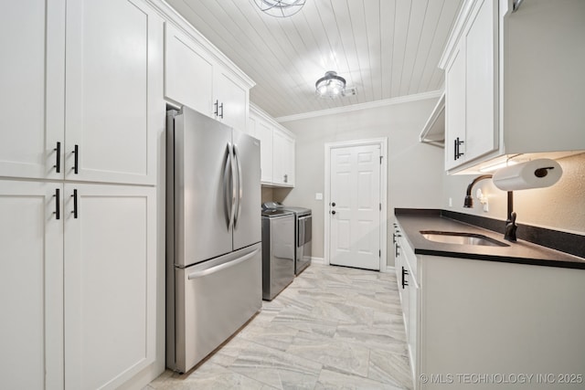 6140 E 140th St S, Bixby, OK 74008 - kitchen featuring freestanding refrigerator, washing machine and dryer, dark countertops, white cabinetry, and light marble finish flooring
