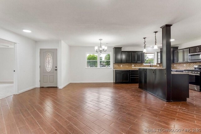 1706 S Madison Blvd, Bartlesville, OK 74006 - kitchen with appliances with stainless steel finishes, a chandelier, healthy amount of natural light, backsplash, and recessed lighting