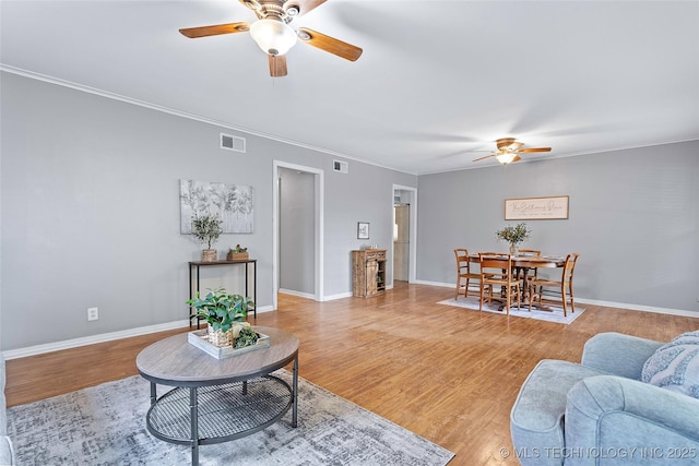 1809 Robison, Ardmore, OK 73401 - living room featuring ceiling fan, light wood-type flooring, and crown molding