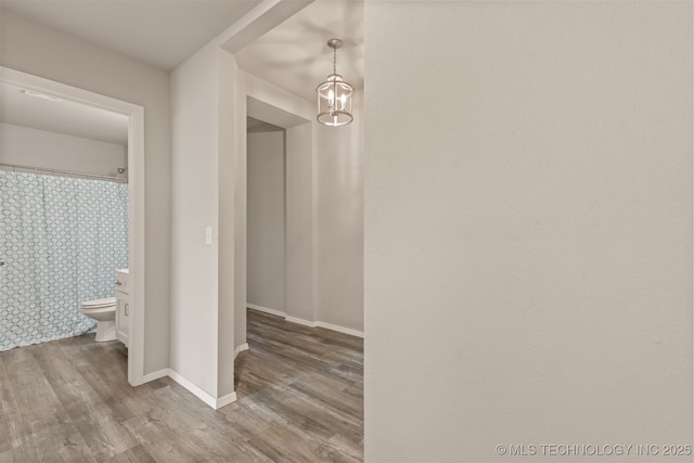 13009 E 124th Ct, Collinsville, OK 74021 - hallway with wood finished floors and a chandelier