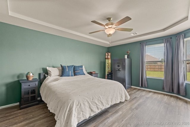 13009 E 124th Ct, Collinsville, OK 74021 - bedroom with a tray ceiling, wood finished floors, and ceiling fan