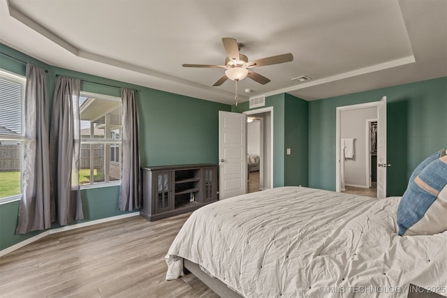 13009 E 124th Ct, Collinsville, OK 74021 - bedroom with wood finished floors, a tray ceiling, and ceiling fan
