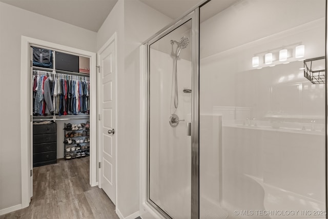 13009 E 124th Ct, Collinsville, OK 74021 - bathroom featuring a stall shower, wood finished floors, and a spacious closet
