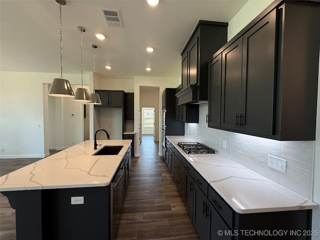8940 E 161st Pl S, Bixby, OK 74008 - kitchen featuring stainless steel gas stovetop, dark wood finished floors, light stone countertops, tasteful backsplash, and recessed lighting
