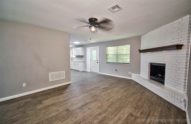 1619 Quail Run, Muskogee, OK 74403 - unfurnished living room with ceiling fan, dark wood-type flooring, and a fireplace
