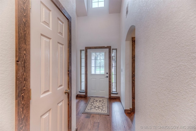 17542 W 1st St S, Sand Springs, OK 74063 - entrance foyer with healthy amount of natural light, arched walkways, dark wood-style flooring, a towering ceiling, and a textured wall