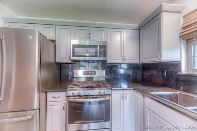 17542 W 1st St S, Sand Springs, OK 74063 - kitchen with stainless steel appliances, decorative backsplash, and a textured ceiling