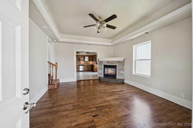 521 S Chickasaw Ave, Claremore, OK 74017 - unfurnished living room with a tray ceiling, stairway, wood finished floors, and ceiling fan