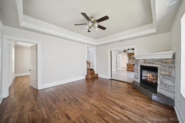 521 S Chickasaw Ave, Claremore, OK 74017 - unfurnished living room with a raised ceiling, ceiling fan, a fireplace, stairs, and crown molding