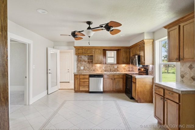521 S Chickasaw Ave, Claremore, OK 74017 - kitchen featuring appliances with stainless steel finishes, ceiling fan, tasteful backsplash, light countertops, and brown cabinets