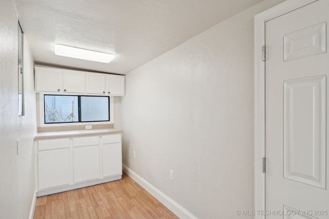 521 S Chickasaw Ave, Claremore, OK 74017 - kitchen with light wood finished floors, white cabinets, and light countertops