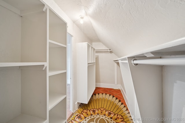 521 S Chickasaw Ave, Claremore, OK 74017 - walk in closet with vaulted ceiling and tile patterned flooring