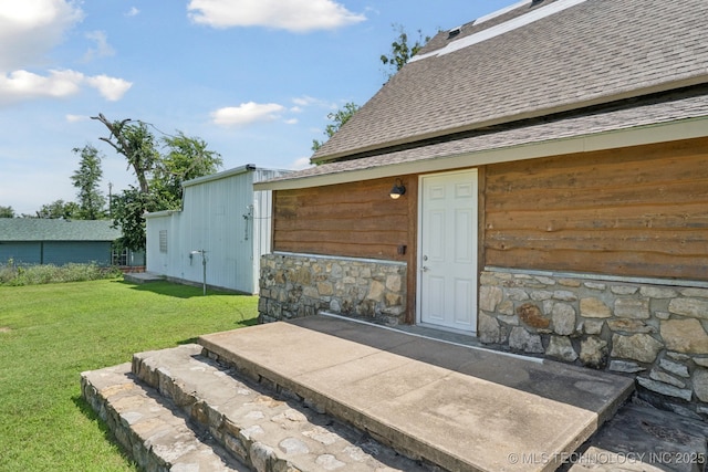 521 S Chickasaw Ave, Claremore, OK 74017 - view of exterior entry featuring a shingled roof, a yard, and stone siding