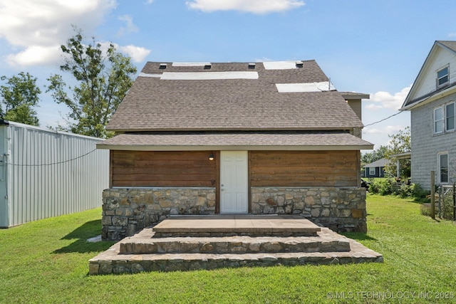 521 S Chickasaw Ave, Claremore, OK 74017 - back of property with a shingled roof, a lawn, and stone siding
