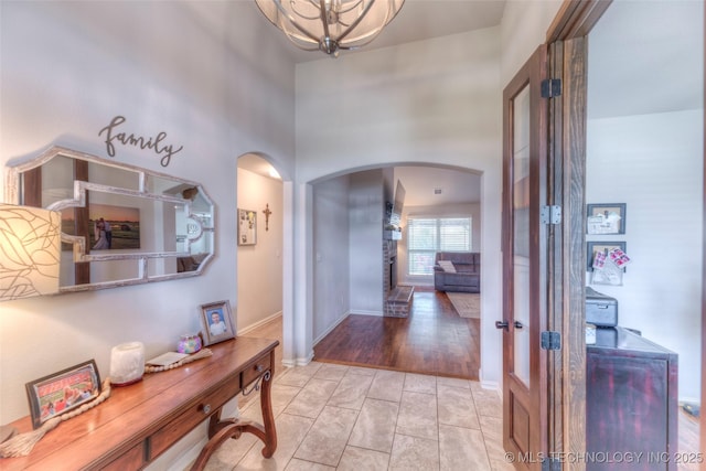 5440 Skylane Pl, Sand Springs, OK 74063 - hallway with arched walkways, french doors, a high ceiling, and a chandelier
