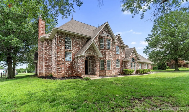 10295 E Rose Glen Dr, Claremore, OK 74019 - view of front facade with a chimney, a front lawn, brick siding, and a shingled roof