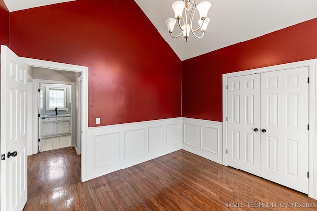 10295 E Rose Glen Dr, Claremore, OK 74019 - unfurnished dining area featuring a wainscoted wall, a chandelier, dark wood-style floors, and high vaulted ceiling