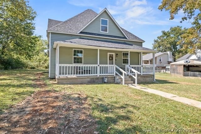 207 N Graham Ave, Wagoner, OK 74467 - view of front facade featuring a porch, roof with shingles, and a front yard