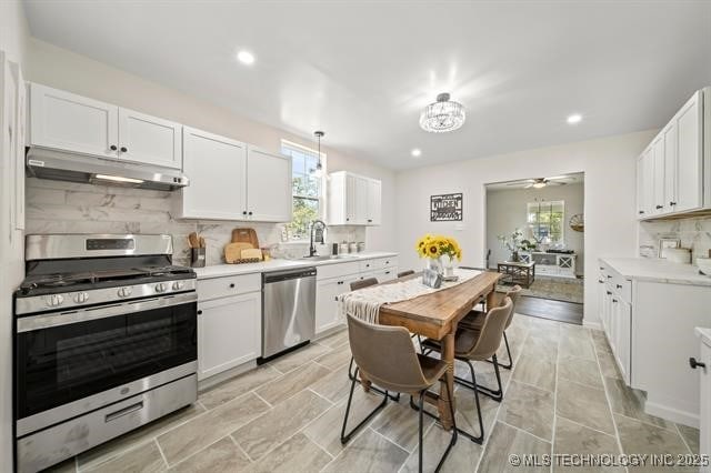 207 N Graham Ave, Wagoner, OK 74467 - kitchen featuring appliances with stainless steel finishes, under cabinet range hood, healthy amount of natural light, backsplash, and recessed lighting