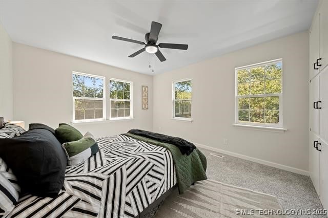 207 N Graham Ave, Wagoner, OK 74467 - bedroom with light colored carpet and ceiling fan
