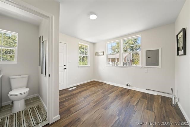 207 N Graham Ave, Wagoner, OK 74467 - spare room with electric panel and dark wood finished floors