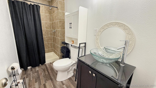 102 N Ash Ave, Tahlequah, OK 74464 - full bathroom featuring wood finished floors, vanity, a tile shower, and a textured wall