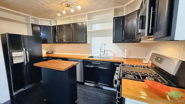 102 N Ash Ave, Tahlequah, OK 74464 - kitchen featuring butcher block counters, stainless steel appliances, open shelves, a center island, and dark cabinetry