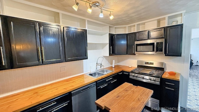 102 N Ash Ave, Tahlequah, OK 74464 - kitchen with stainless steel appliances, wooden counters, dark cabinets, and open shelves
