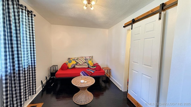 102 N Ash Ave, Tahlequah, OK 74464 - bedroom featuring a barn door, a textured ceiling, and wood finished floors