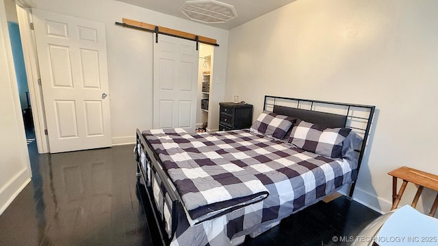 102 N Ash Ave, Tahlequah, OK 74464 - bedroom featuring a barn door and wood finished floors
